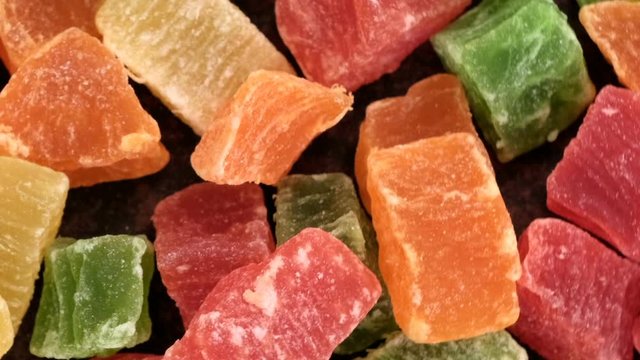 Grocery video splash, rotating background of slices of dried mango, pineapple, banana and other tropical fruits, close-up top view using zoom and move the camera
