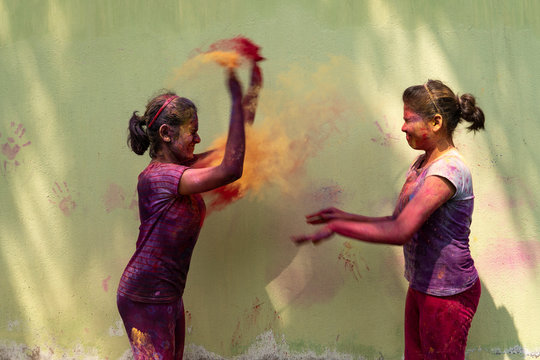 Two Teenage Girls Throwing Gulal During Holi Festival