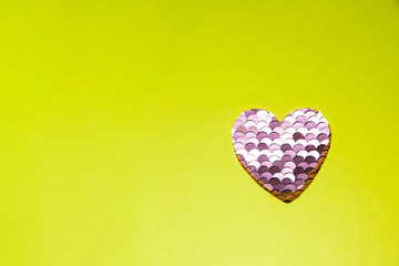 Sequined heart valentine of sequins on yellow background. Valentine card with pink hearts. Fashion pink shining sequins in the shape of a heart.love and valentine concept.Copy space