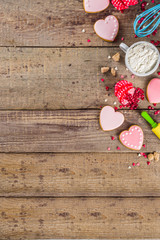Valentine day cooking baking background. Utensils and ingredient for sweet Valentine cakes and heart shaped cookies, wooden background copy space