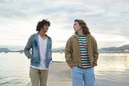 Young casual men walking on pier