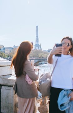 Two friends taking pictures on the Alexandre III bridge in Paris France