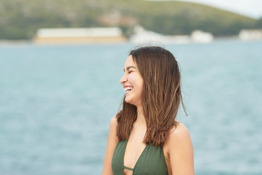 Laughing teen girl on seashore