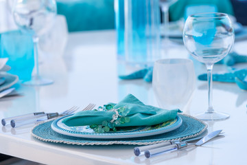 Beautiful table setting with blue plates, napkins and wine glasses - Powered by Adobe
