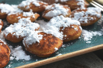 'Poffertjes', a traditional Dutch batter treat dish resembling small, fluffy pancakes, served with powdered sugar and butter