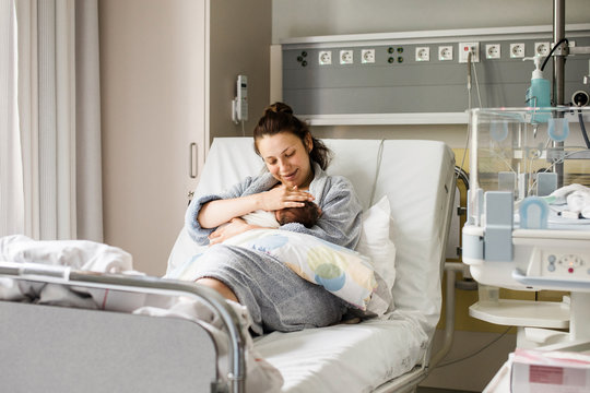Mother breastfeeding her newborn baby boy in hospital