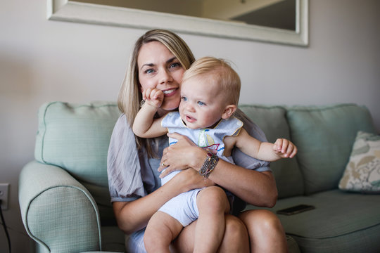 happy mother holds her squirming toddler