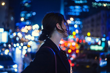 Young woman standing outdoors at night