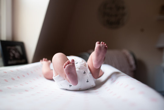 little feet of newborn baby on changing table