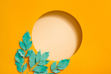 Creative layout made with leaves on bright orange background