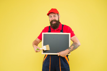Builder regular worker. Repair and renovation. Quick repair. Creative decorator. Painting works. Bearded decorator hold chalkboard advertisement copy space. Repair tips. Man worker with paint brush