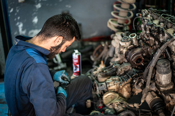 Car service and maintenance: an automechanic is repairing a vehicle