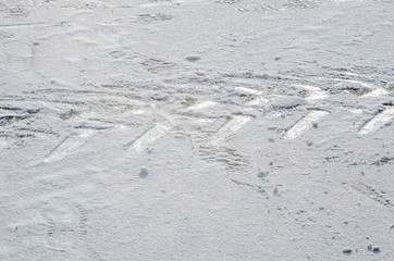 Imprints of tire tracks on white winter snow. The concept of laying a road / path. The concept of preparing the car for the winter season.