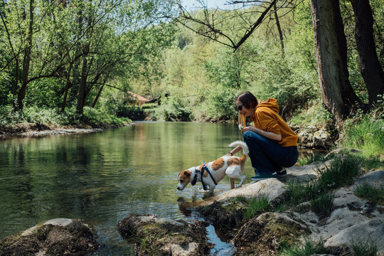 Woman and her dog standing by the river - Powered by Adobe