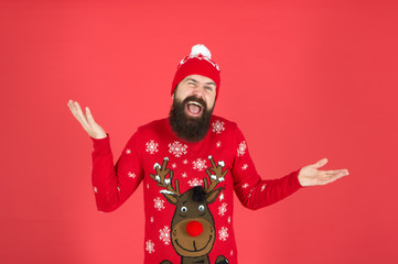 Fototapeta na wymiar I do not care. Buy festive clothing. Sweater with deer. Hipster cheerful bearded man wear winter sweater and hat. Happy new year. Join holiday party craze and host ugly christmas sweater party.