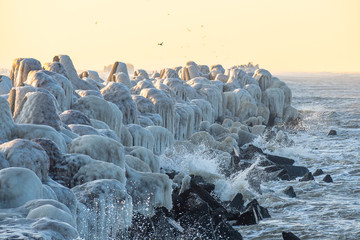 The breakwater is covered with ice after a winter storm.