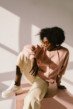 Relaxed black woman sitting on cube