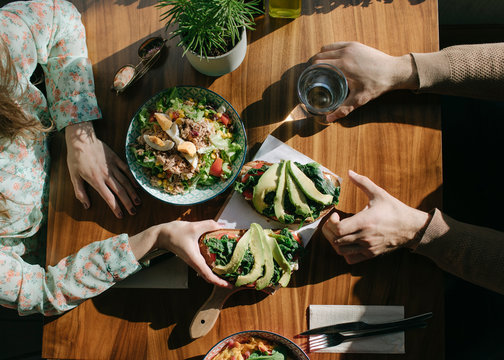 Overhead view of couple eating avocado toast