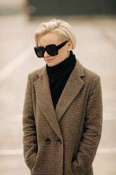 Portrait Of Young Blond Androgyne Woman with big sunglasses
