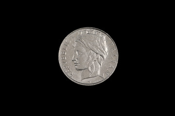 A close up image, shot in macro of an old Italian one hundred lira coin, shot against a black background
