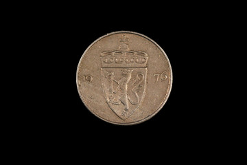 A close up, macro image of an Norwegian fifty ore coin isolated on a black background