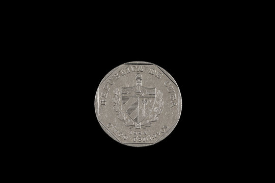 A close up image of an old Cuban coin, shot in macro, isolated on a black background