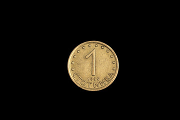 A close up image of a gold one stotinki coin from Bulgaria, shot in macro, on a solid black...