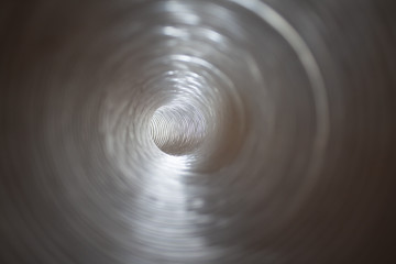 Optical illusion of photo. Futuristic plastic pipe inside iridescent swirling spiral. Bright...