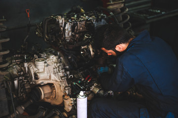 Car service and maintenance: an automechanic is repairing a vehicle