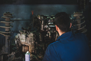 Obraz na płótnie Canvas Car service and maintenance: an automechanic is repairing a vehicle