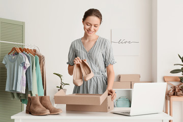 Young woman preparing parcel for client in office