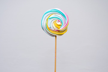 Lollipop candy for kids and adults on a wooden stick on a white background. Sucking sweets for the holiday, sugar confectionery.