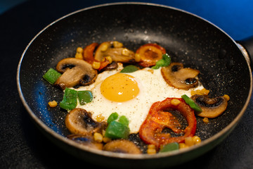 Freshly fried eggs with vegetables in a pan