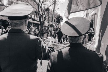 Soldiers holding flowers and flag during a memorial procession.