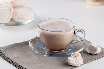 Fototapeta na wymiar Cup of hot latte coffee with marshmallows on a white table