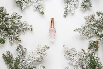 Christmas still life. Spruce branches form a frame with perfume bottle in the middle