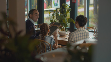 Man gives a present to woman in cafe