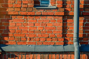 Brick wall. Fragment of a brick building. Red old brick. Vintage background. The texture of the wall.