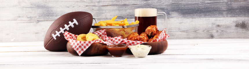 chicken wings, fries and onion rings for football on a table. Great for Bowl Game party