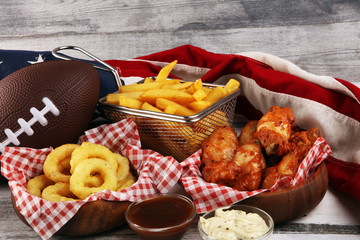 chicken wings, fries and onion rings for football on a table. Great for Bowl Game party