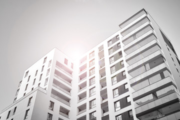 Detail of modern residential flat apartment building exterior. Fragment of new luxury house and home complex. Glass surface with sunlight. Black and white.