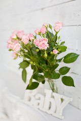 Bouquet of little pink roses with white wooden word 