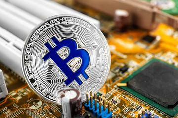 Silver bitcoin on PC circuit board