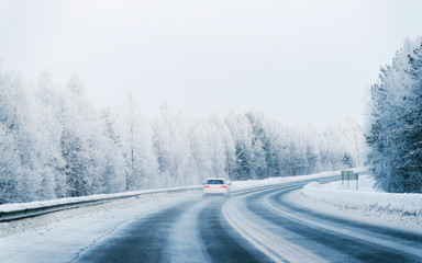 Fototapeta na wymiar Car on Winter road with snow in Finland. Auto and Cold landscape of Lapland. Automobile on Europe forest. Finnish City highway ride. Roadway and route snowy street trip. Driving