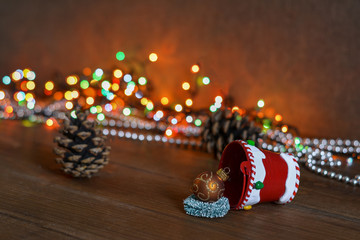 New Year card - a bucket of gifts on a wooden background, multi-colored garland. New Year and Christmas gifts.