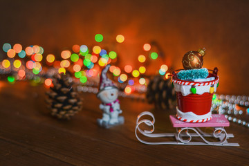 New Year 2020 - a bucket with gifts on a sled and a snowman. Gifts for the new year, for Christmas. Congratulations on the winter holidays.