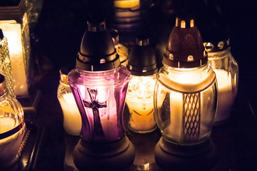 Monument and candles in the cemetery. All Saints Day in Poland. Candles in the cemetery. All candles in the dark.