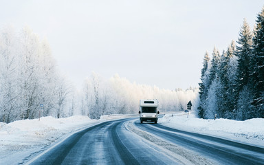 Mini Van on Winter road with snow in Finland. Car and cold landscape of Lapland. Europe forest....