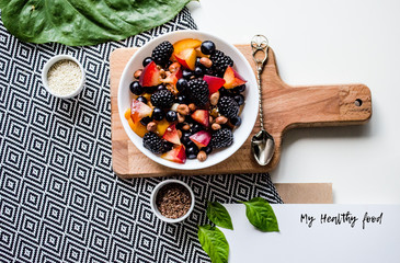 Creative layout  of a healthy breakfast. A composition of fresh summer fruits, muesli, grains, plums on a cutting board and tablecloth. Healthy food. Top view with space for text.
