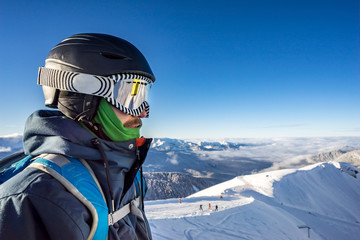 Portrait of young snowboarder in helmet and sunglass mask at the ski resort Rosa Khutor on...